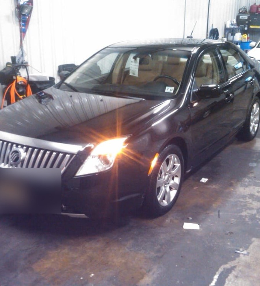 A freshly hand washed and waxed sedan with a deep, glossy black finish